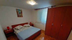 Ein Schlafzimmer mit einem Bett, Nachttischen, einem Kleiderschrank und einem Bild an der Wand.