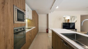 Una cocina moderna con armarios de madera, electrodomésticos de acero inoxidable y una isla grande con un lavamanos.