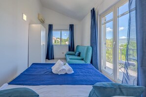 A hotel room with a bed, a chair, and a view of the outdoors. - Five Bedroom House with Jaccuzi (Slatine)
