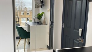 A modern room with a green chair, a white desk, and a dark door. - BPR Private Hot-tubs and rooms  (London)