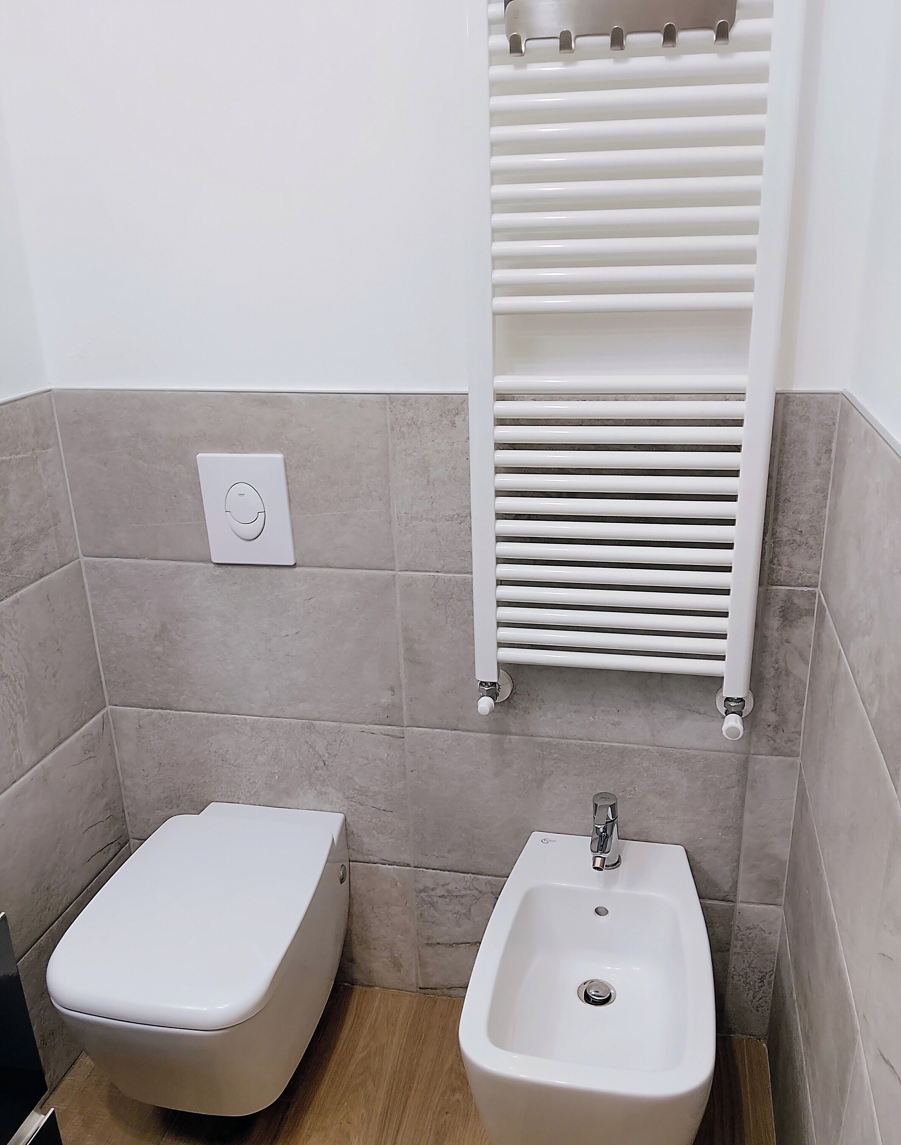 Ein Badezimmer mit Toilette, Bidet und Handtuchhalter.
