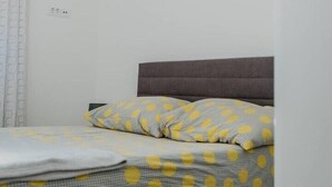 Ein Schlafzimmer mit einem Bett, einem Kopfteil und einem an der Wand befestigten Kunstwerk.