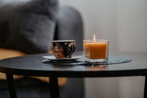 Eine Tasse und eine Kerze auf einem kleinen runden Tisch.