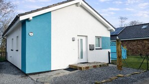Un bâtiment d’un seul étage, à la façade blanche et bleue, doté d’un petit porche à l’avant et d’un panneau indiquant clairement le numéro « 5 ».