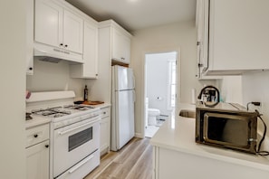 A kitchen with white cabinets, a stove, a refrigerator, and a microwave. - 1 Mi to Main Street! Cozy Concord Apartment (Concord)
