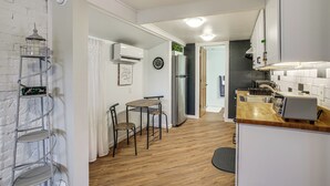 A modern kitchen with white cabinetry, a wooden countertop, and a built-in toaster. - Work & Play in Walkable Midtown Coeur D'alene! (Coeur d'Alene)