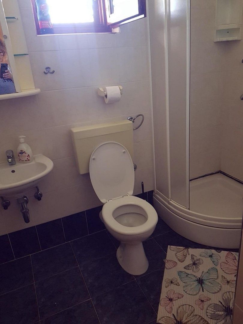 Une salle de bain équipée de toilettes, d’un lavabo et d’une douche.