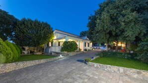 Ein zweigeschossiges Haus mit gepflasterter Auffahrt und einem gepflegten Rasen.
