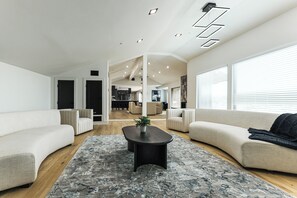 A modern living room with a central coffee table, two sofas, and a large window. - Luxurious Austin Hideaway! 4,400-sq-ft Estate (Austin)