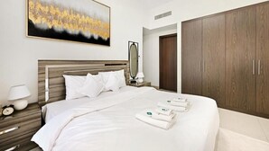 Et hotelværelse med en stor seng, et træskab, et natbord med en lampe og et billede på væggen.