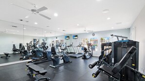 A gym with various exercise equipment, including treadmills, weight machines, and free weights. - St. Croix at Pelican Marsh (Naples)