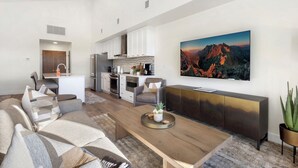 A modern living room with a wooden coffee table, a sofa, and a TV mounted on the wall. - New Listing! Peaceful Riverfront Living | Deck with Views | Walk to Downtown (Ridgway)