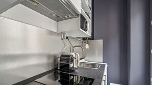 Eine moderne Küche mit Einbauherd, Kaffeemaschine und Spüle.