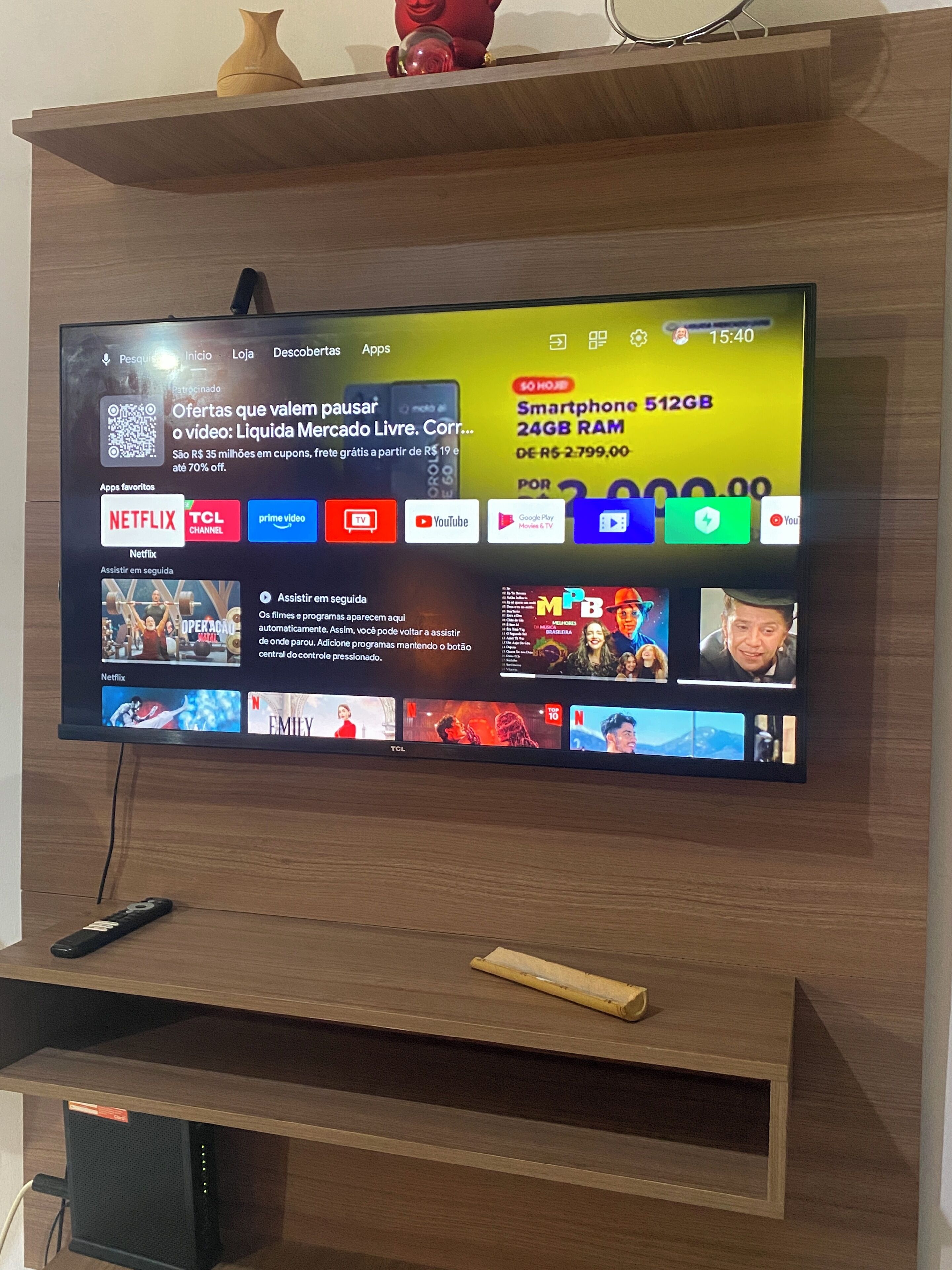 A flat-screen TV mounted on a wooden wall, displaying a streaming service interface with various apps and content.