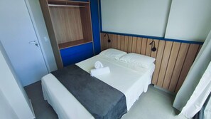 Ein Hotelzimmer mit einem Bett, einem Kleiderschrank und einer Wandleuchte.