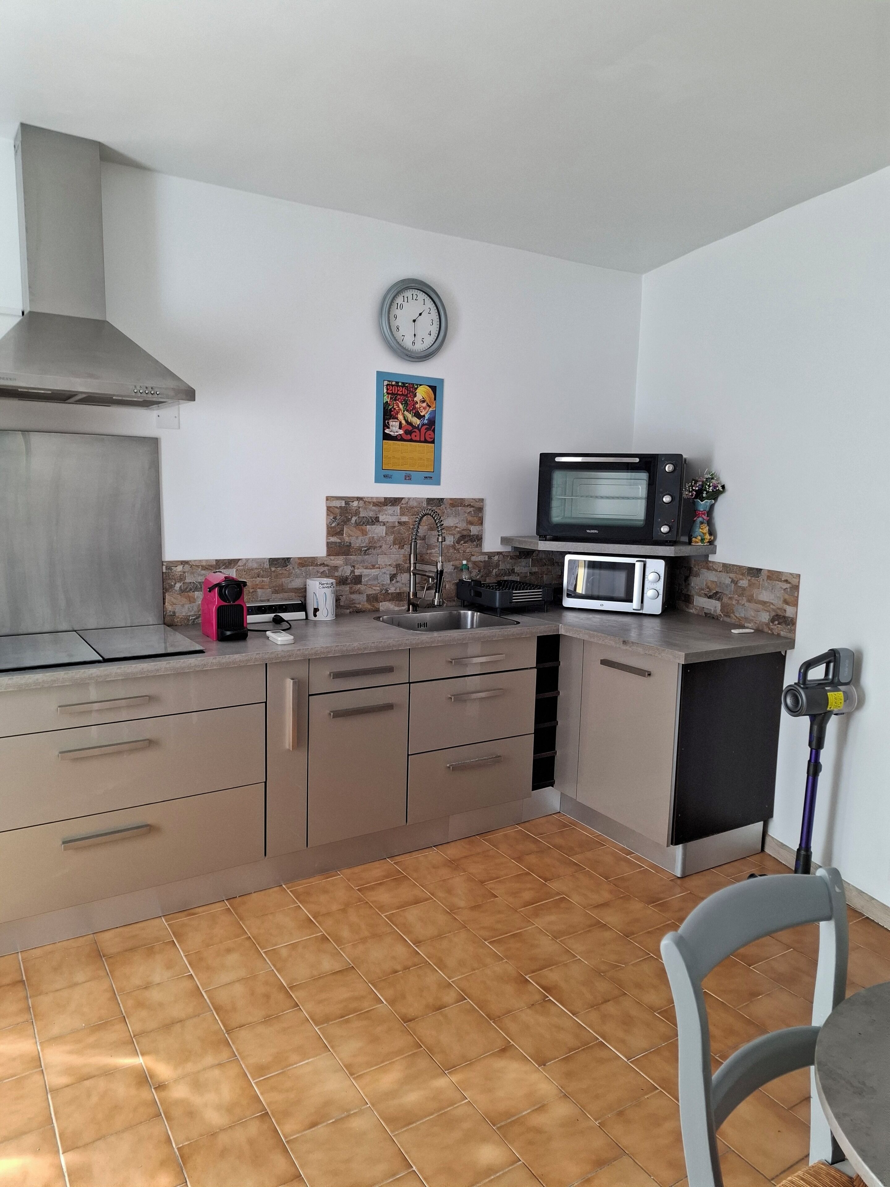 Een moderne keuken met roestvrijstalen apparatuur, een magnetron en een spoelbak.