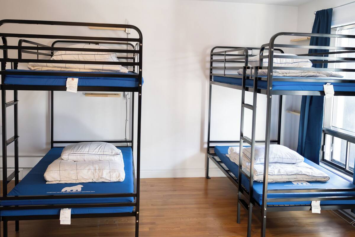 Bunk beds in a room with wooden flooring and white walls.