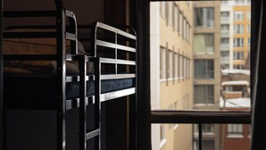 A bunk bed room with a window view of a cityscape. - Treehouse Hostel (Montreal)