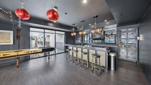 A modern bar area with a long counter, stools, and a bar stool trash can. - Luxury 1 BR I Walk to Mayo Skyway I Pets I Parking (Rochester)