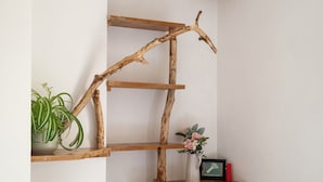 Een houten plank met takken, een bloempot en een vaas met bloemen.