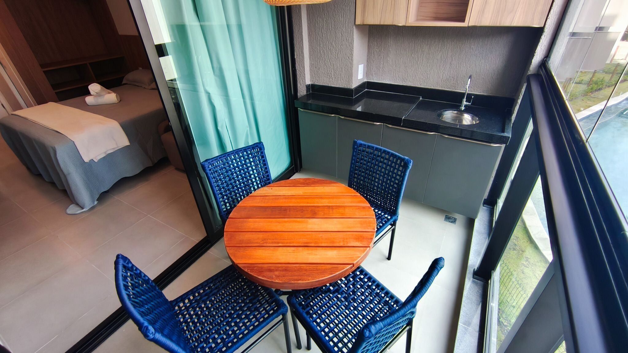 A compact kitchen with a dining area, a small sleeping area, and a view of the outdoors.