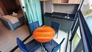 A compact kitchen with a dining area, a small sleeping area, and a view of the outdoors. - Nomar Carneiros Ecoliving by CTA (Tamandaré)