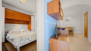 Une chambre à coucher avec un lit, un bureau et un téléviseur.