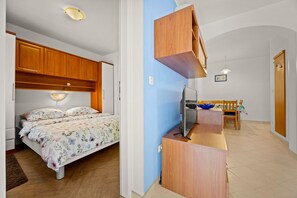 Ein Schlafzimmer mit einem Bett, einem Schreibtisch und einem Fernseher.