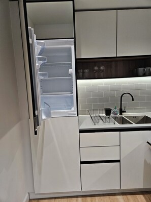 A modern kitchen with white cabinetry, a black countertop, and a stainless steel sink. - Luxury 2BR 2Bath Flat in London |Balcony|Parking|Short walk to Colindale station (Edgware)