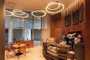 A modern dining area with a wooden bar, circular lighting fixtures, and a glass partition. - 1BR Haven | Pool & Ocean | WC Miami Stadium Trip (Hollywood)