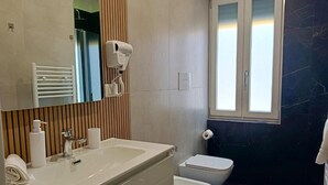 A modern bathroom with a large sink, a toilet, and a bidet. There is a towel rack and a mirror above the sink. - MARILU' ACCOGLIENZA DEL SUD (Foggia)