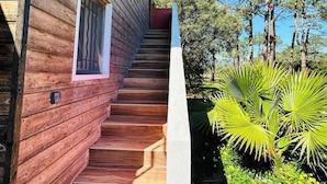 Una scala di legno conduce a una casa con una piccola finestra e un lampadario.