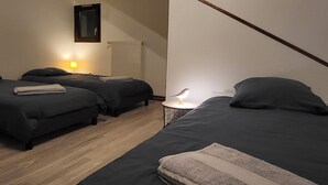 A room with two beds, a small table with a lamp, and a radiator. - Wonderful 2-bedroom apartment in Évette-Salbert perfect for relaxing stay (Évette-Salbert)