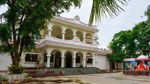 A multi-story building with a symmetrical facade, arched windows, and a central entrance. - Sanjay Resort Baghela Heritage (Majhauli)