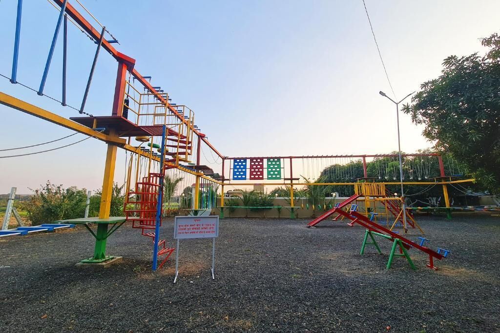 A playground with swings, climbing structures, and a sign.