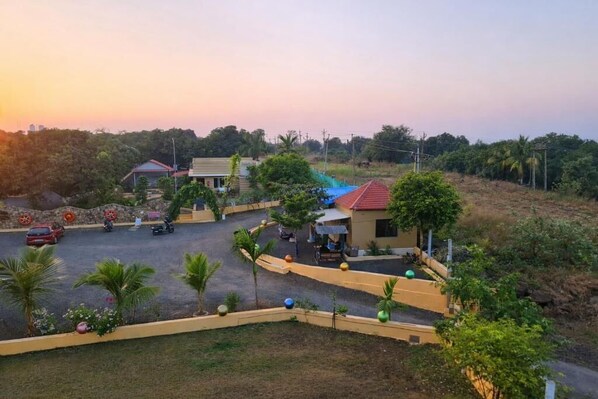 A residential area with houses, a paved road, and a small parking area.