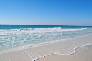 A beach with clear blue water and waves gently lapping onto the shore. - 115 Island Princess ~NewBeachfrontProperty~FREE BEACHSVC~FREELOCAL ACTIVITIES (Fort Walton Beach)