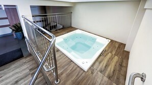 A modern indoor pool area with a wooden floor, a metal railing, and a spa tub. - Evian Thermas Residence by Trul Hoteis (Caldas Novas)
