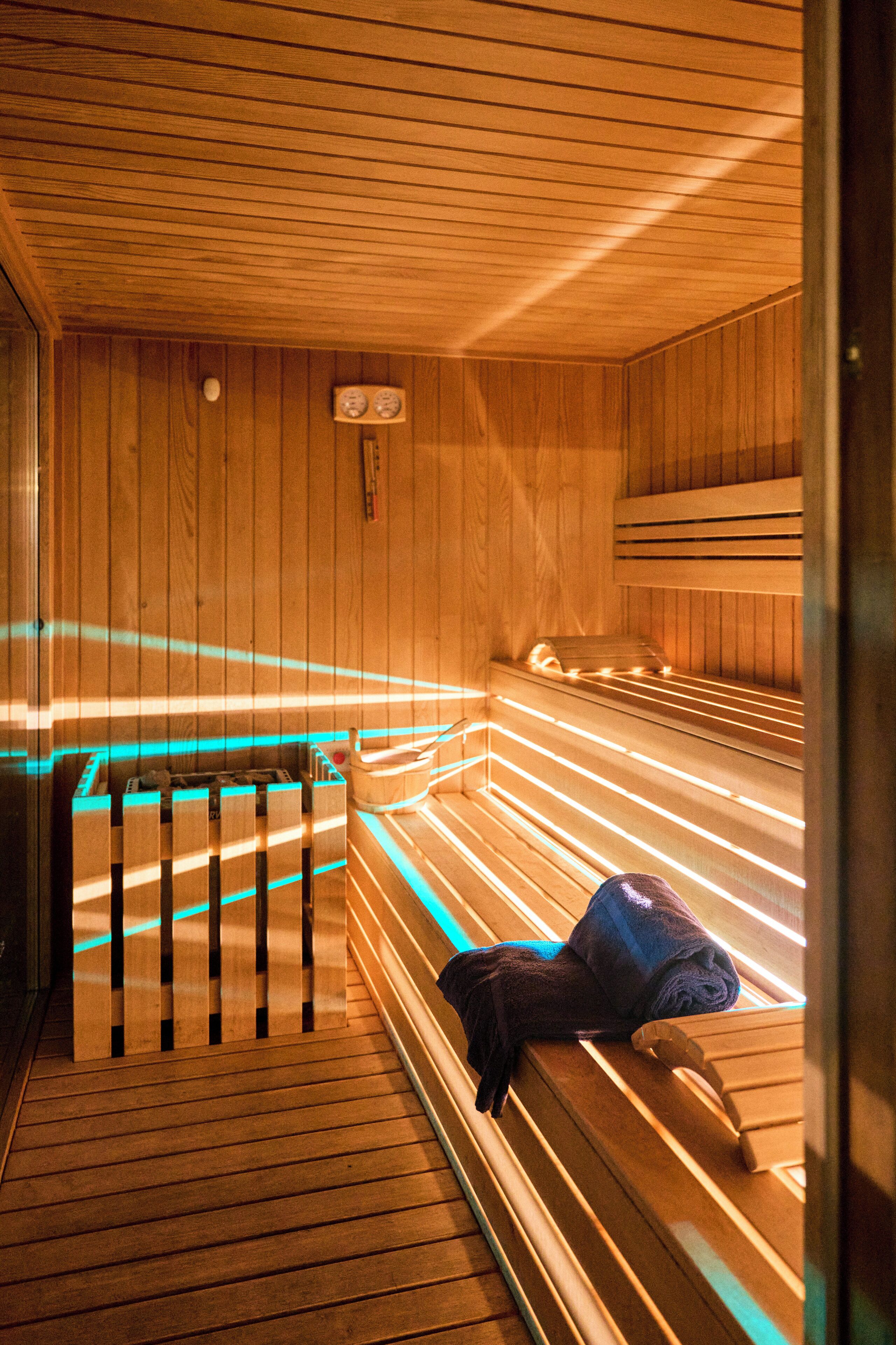 A wooden sauna with benches and a bench with a towel.