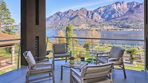 A balcony with two chairs and a table, overlooking a lake and mountains. - Bellagio Village (Oliveto Lario)