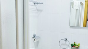 Een moderne badkamer met toilet, bidet en een kleine prullenbak.