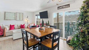 A cozy dining area with a wooden table and chairs, a ceiling fan, and a Christmas tree. - Ashley's Forgetaway For 4 (Branson)