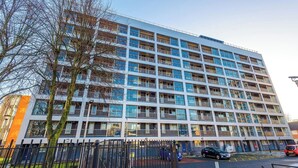 A multi-story building with a modern architectural design, featuring a series of balconies and large windows. - 1-Bed Flat | Hume | 5 Min to MMU & UoM | 15% Off (Greater Manchester)