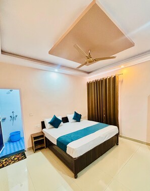 Ein Hotelzimmer mit Bett, Deckenventilator, Dusche und Vorhang.