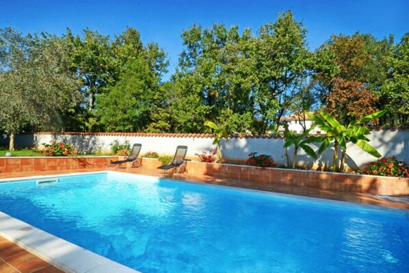 A swimming pool with lounge chairs and a tiled deck. - Apartment With Pool Near Kanegra Beach (Umag)