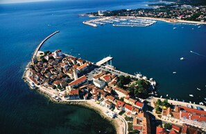 An aerial view of a coastal town with a central square, waterfront buildings, and a marina. - Apartment With Pool Near Kanegra Beach (Umag)
