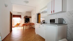 A compact kitchen with white cabinets, a microwave, and a coffee maker on the counter. - Apartment With Pool Near Kanegra Beach (Umag)