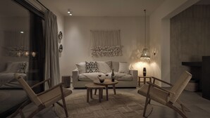 A modern living room with a sofa, two wooden chairs, a coffee table, and a large window with curtains. - Bianco Boutique Villas - Eve (33F2+9P2 Pefki, Greece)