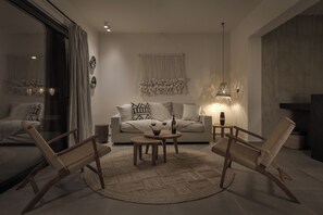 A modern living room with a sofa, two wooden chairs, a coffee table, and a large window with curtains. - Bianco Boutique Villas - Eve (33F2+9P2 Pefki, Greece)