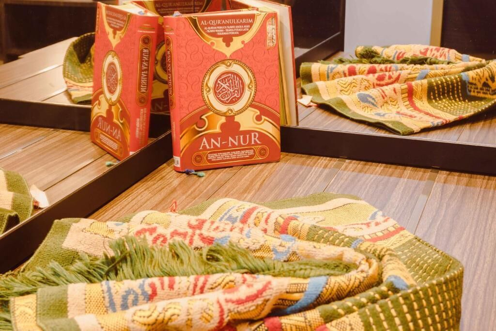 A display of traditional woven rugs and boxes labeled "AN-NUR" in a retail setting.